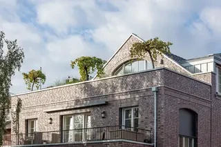 Obergeschoss und Dachbereich der Stadtvilla mit Backsteinfassade, Gauben und begrüntem Terrassenbereich