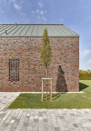 Minimalistische Giebelfassade eines modernen Einfamilienhauses mit dunklem Klinker und Metall­dach in Hamburg.