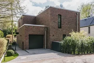 traßenansicht eines kubischen Klinkerhauses in Hamburg mit integrierter Garage und rustikaler bunter Fassade aus Wittmunder Klinker 68 DF.